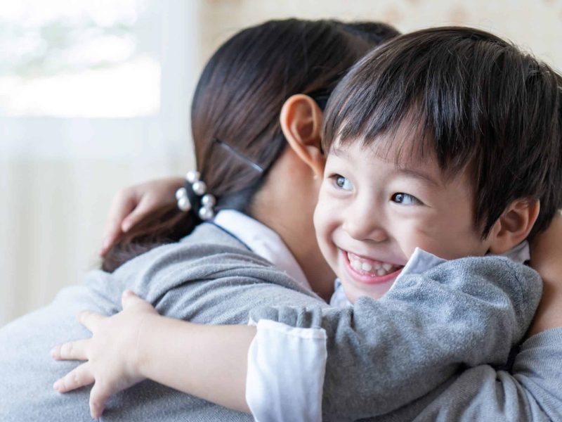 Asian cute boy smiling with happily and hugging with mother at home, copy space, family concept